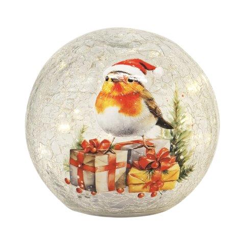 A round, crackle-glass decorative ornament featuring a painted robin wearing a Santa hat, perched above wrapped Christmas presents with red bows and small evergreen sprigs, on a white background.