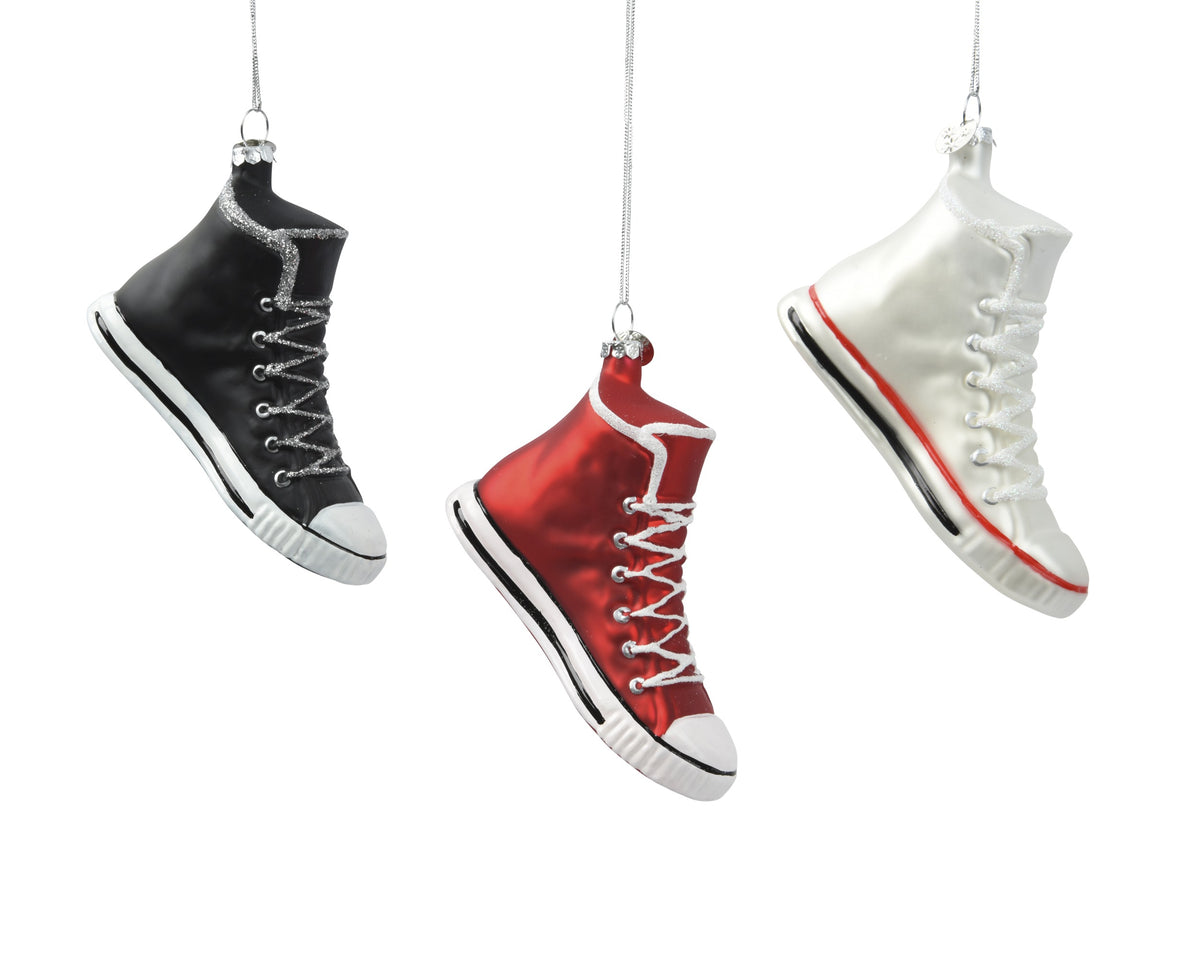 Three high-top sneakers in black, red, and white hanging against a white background.