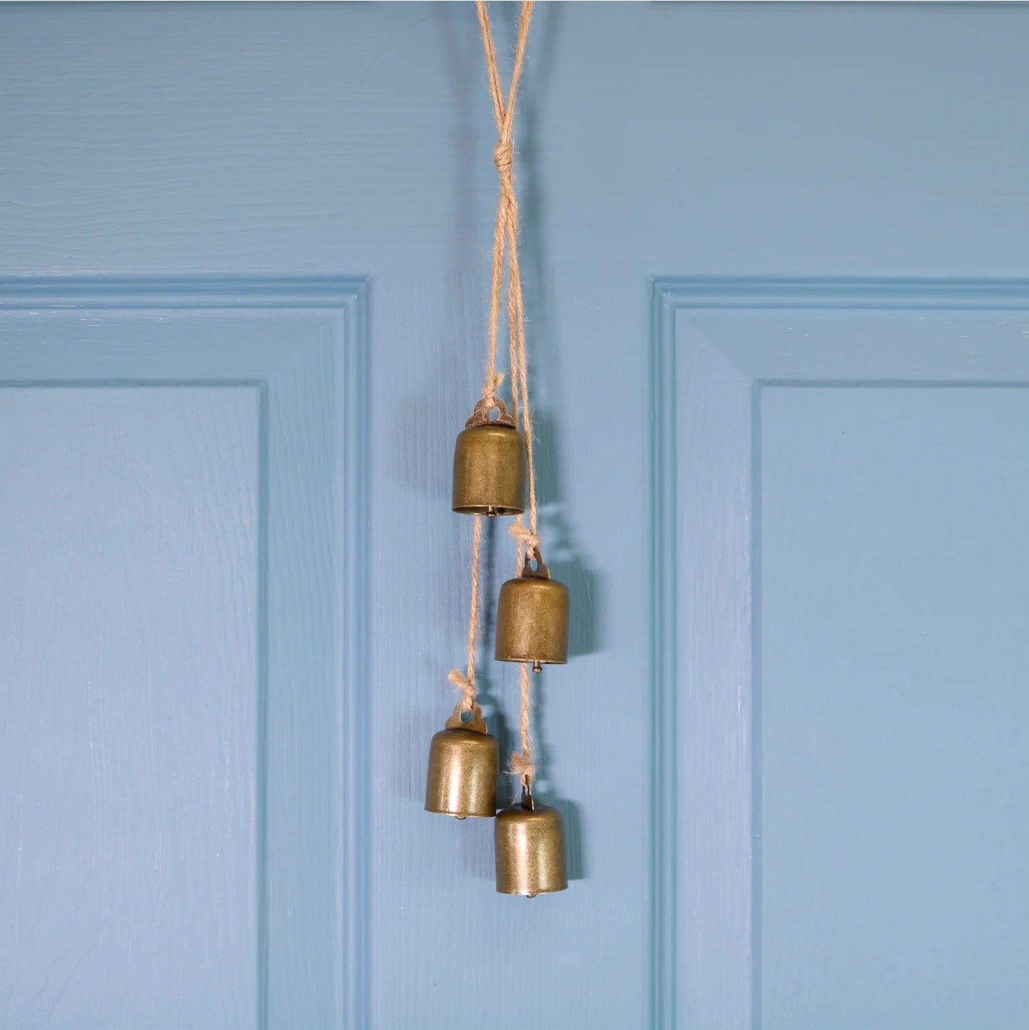 Bells on twine to hang on your door. Shown on a blue background
