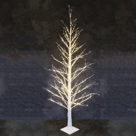 A bare tree-shaped decorative light with warm white LED lights on a white square base, photographed against a dark textured studio background.
